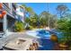 A serene backyard featuring a freeform pool, stone firepit, and mature landscaping at 886 White Point Blvd, Charleston, SC 29412
