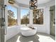Modern bathroom with a soaking tub under large windows that bring in natural light at 886 White Point Blvd, Charleston, SC 29412