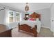 Bright bedroom with a wooden bed frame, chandelier, and natural light from large windows at 886 White Point Blvd, Charleston, SC 29412