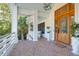 Charming front porch with brick flooring, white columns, and stylish front door at 886 White Point Blvd, Charleston, SC 29412