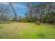 Spacious backyard with green grass, trees, and a charming brick structure, ideal for outdoor activities and gatherings at 1024 Locksley Dr, Charleston, SC 29407