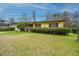 Quaint single-story home with a manicured lawn, mature shrubs, and a gravel driveway leading to a welcoming entrance at 1024 Locksley Dr, Charleston, SC 29407