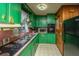 Galley kitchen with green cabinets, appliances, and wood paneled walls at 1024 Locksley Dr, Charleston, SC 29407