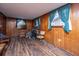 Cozy living room with wood paneling, hardwood floors, and large windows, offering a warm and inviting atmosphere at 1024 Locksley Dr, Charleston, SC 29407