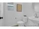 A well-lit half bathroom offers modern fixtures, a pedestal sink, and decorative wall art at 1058 Marsh Harrier Dr # 15-7P, Ravenel, SC 29470