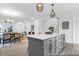 Spacious kitchen island with seating, gray cabinets, and pendant lighting opens to the dining and living areas at 1058 Marsh Harrier Dr # 15-7P, Ravenel, SC 29470