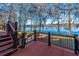 Wooden deck with ornate railings overlooking a tranquil lake surrounded by trees at 105 Goose Creek Dr, Goose Creek, SC 29445