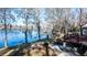 Lakeside backyard with mature trees, patio, deck, and tranquil water views at 105 Goose Creek Dr, Goose Creek, SC 29445