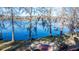 Lakeside backyard featuring mature trees, a brick patio, and tranquil water views at 105 Goose Creek Dr, Goose Creek, SC 29445