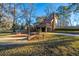 Back view of a brick and siding home with deck, complemented by a driveway and well-maintained lawn at 105 Goose Creek Dr, Goose Creek, SC 29445