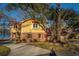 Well-kept yellow house with a red-roofed garage, a spacious driveway, and a serene waterfront view at 105 Goose Creek Dr, Goose Creek, SC 29445
