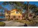 Inviting yellow home with red accents and a glimpse of waterfront, enhanced by mature trees and a well-maintained lawn at 105 Goose Creek Dr, Goose Creek, SC 29445