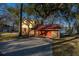Detached garage with a red roof, driveway, and partial home view with waterfront in the background at 105 Goose Creek Dr, Goose Creek, SC 29445