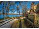 Scenic view of a waterfront property with mature trees, a picket fence, and a winding pathway to the house at 105 Goose Creek Dr, Goose Creek, SC 29445