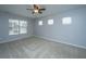 A bright bedroom featuring three windows, a ceiling fan, and neutral carpet at 106 Willet Dr, Summerville, SC 29485