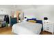 Serene bedroom with hardwood floors, white walls, and a comfortable bed with blue and yellow pillows at 1195 Marquis Rd, North Charleston, SC 29405
