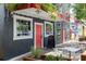 Street view of commercial building exterior with red door and awning, sidewalk seating, and inviting entrance at 1195 Marquis Rd, North Charleston, SC 29405