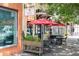 Street view of an inviting restaurant exterior with red umbrellas, flower planters, and sidewalk tables at 1195 Marquis Rd, North Charleston, SC 29405