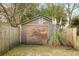 Backyard shed with a wooden door, surrounded by lush foliage and a wooden fence at 1195 Marquis Rd, North Charleston, SC 29405
