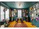 Unique sitting room with dark teal walls, decorated with an array of unique artwork and a desk at 1195 Marquis Rd, North Charleston, SC 29405