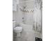 Well lit bathroom featuring a shower-tub combo, white tile and a white floral shower curtain at 130 River Landing Dr # 7309, Charleston, SC 29492