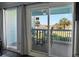 Balcony view with a table and chairs, overlooking landscaped grounds and palm trees on a sunny day at 1300 Ocean Blvd # 102 A, Isle of Palms, SC 29451