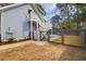 The fenced-in backyard includes stairs to an upper deck and a walkway to a paved area with patio furniture at 1328 Erckmann Dr, Mount Pleasant, SC 29464