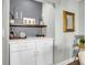 Close up of the bar area featuring white cabinets, a wooden shelf and decorative accents at 1347 Cadence Dr, Mount Pleasant, SC 29466