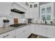 Close-up of kitchen featuring white cabinetry, granite countertop, modern appliances, and tile backsplash at 1556 Cranes Nest Rd, Mount Pleasant, SC 29466