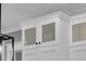 Close-up of white kitchen cabinets featuring glass fronts and detailed trim work at 1556 Cranes Nest Rd, Mount Pleasant, SC 29466