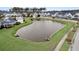 Community pond surrounded by lush green grass and neighborhood homes, offering a serene view at 1556 Cranes Nest Rd, Mount Pleasant, SC 29466
