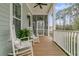 Cozy screened front porch with rocking chairs and fern, creates a perfect space for relaxation and outdoor enjoyment at 1556 Cranes Nest Rd, Mount Pleasant, SC 29466