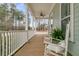 Inviting covered porch with rocking chairs, fern, and white railing offers a relaxing outdoor space at 1556 Cranes Nest Rd, Mount Pleasant, SC 29466