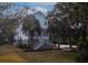 Beautiful two-story coastal home with a white exterior, grand staircase, and lush palm trees at 1648 Home Farm Rd, Mount Pleasant, SC 29464