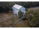 Stunning two-story coastal home with multiple balconies, a silver roof, and lush surrounding trees at 1648 Home Farm Rd, Mount Pleasant, SC 29464