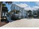 Beautiful three-story beach home with a brick driveway, lush landscaping and outdoor seating at 1648 Home Farm Rd, Mount Pleasant, SC 29464