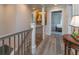 Upstairs hallway with hardwood floors and trim, complemented by a painting and a view of a bedroom at 1648 Home Farm Rd, Mount Pleasant, SC 29464