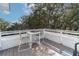 Charming outdoor deck features white railings, a table with seating, and lovely views of the surrounding trees and sky at 1648 Home Farm Rd, Mount Pleasant, SC 29464