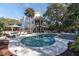Inviting backyard pool and hot tub surrounded by travertine tile and lush landscaping at 1648 Home Farm Rd, Mount Pleasant, SC 29464