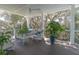 Inviting covered porch features rocking chairs, wood floors, and views of lush trees at 1648 Home Farm Rd, Mount Pleasant, SC 29464