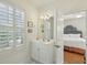 Bright and tidy white bathroom featuring a vanity with a mirror and plantation shutters at 1769 Greenspoint Court, Mount Pleasant, SC 29466