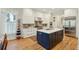 Charming kitchen featuring white cabinets, a navy island, stainless steel appliances, and hardwood floors at 1769 Greenspoint Court, Mount Pleasant, SC 29466