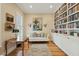 An elegant living room features a bookshelf wall, a vintage table, and bright, natural light at 1769 Greenspoint Court, Mount Pleasant, SC 29466