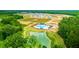 Aerial view of a community pool, playground, pond, and neighborhood surrounded by lush greenery, new development, sunny day at 210 Blue Haw Dr, Moncks Corner, SC 29461