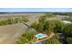 Aerial view showcasing lush trees surrounding the pool and marsh of a neighborhood at 2119 Landfall Way, Seabrook Island, SC 29455