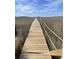 Scenic boardwalk view with wooden planks and rope railing over a beautiful field landscape against a blue sky with clouds at 2119 Landfall Way, Seabrook Island, SC 29455