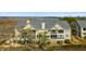 Exterior view of multi-level condo with lush surrounding foliage, chimney, neutral paint, and marshy landscape at 2119 Landfall Way, Seabrook Island, SC 29455