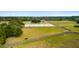 Aerial view of horse farm featuring an outdoor arena, green pastures, and charming stables at 2119 Landfall Way, Seabrook Island, SC 29455