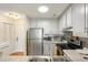 Well-lit kitchen with modern stainless steel appliances, a stainless steel sink, white cabinets, and granite countertops at 2119 Landfall Way, Seabrook Island, SC 29455