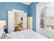 Bedroom features a large window, white linen, and blue accent wall at 214 Calhoun St # 5, Charleston, SC 29401
